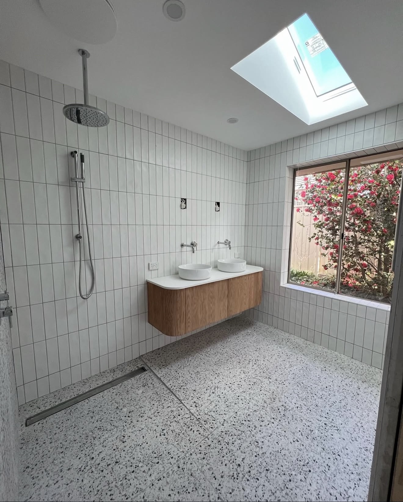 Bathroom with skylight, double vanity and terrazzo floor